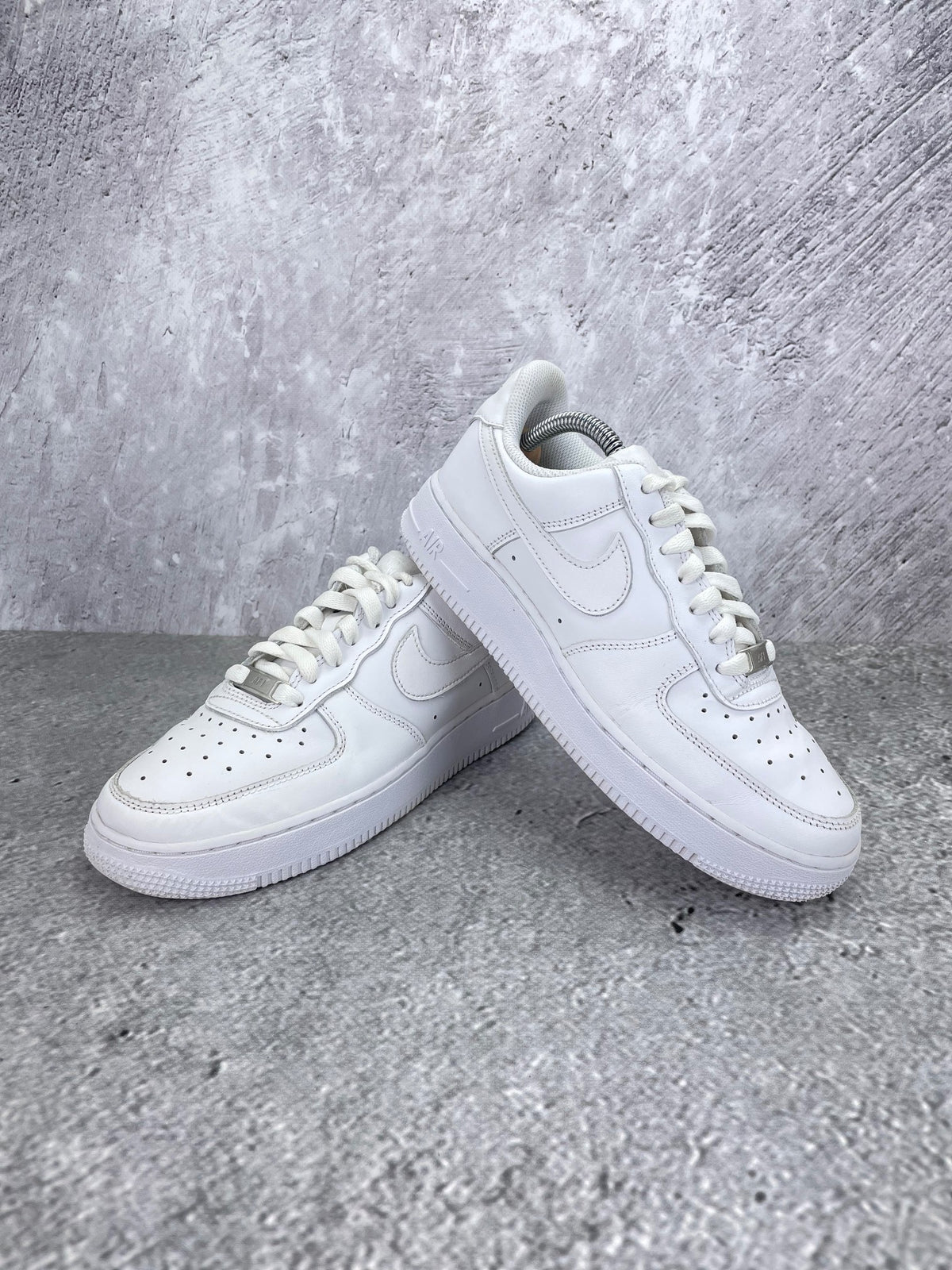 Nike Air Force 1 Low Triple White - buty sportowe, para butów, widok z boku na tle studyjnym