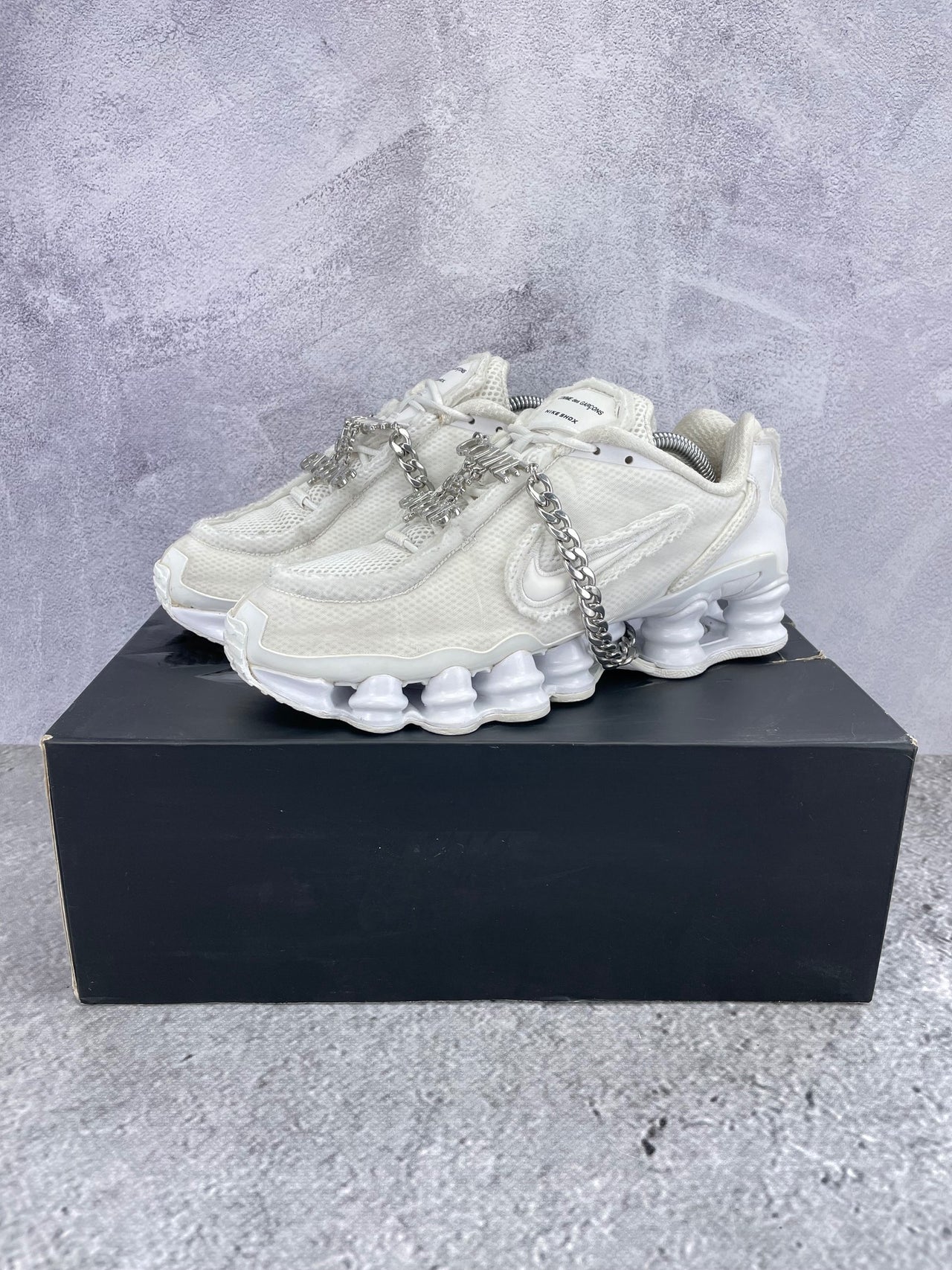 Nike Shox TL / CDG Triple White - buty sportowe, widok z boku na tle studyjnym