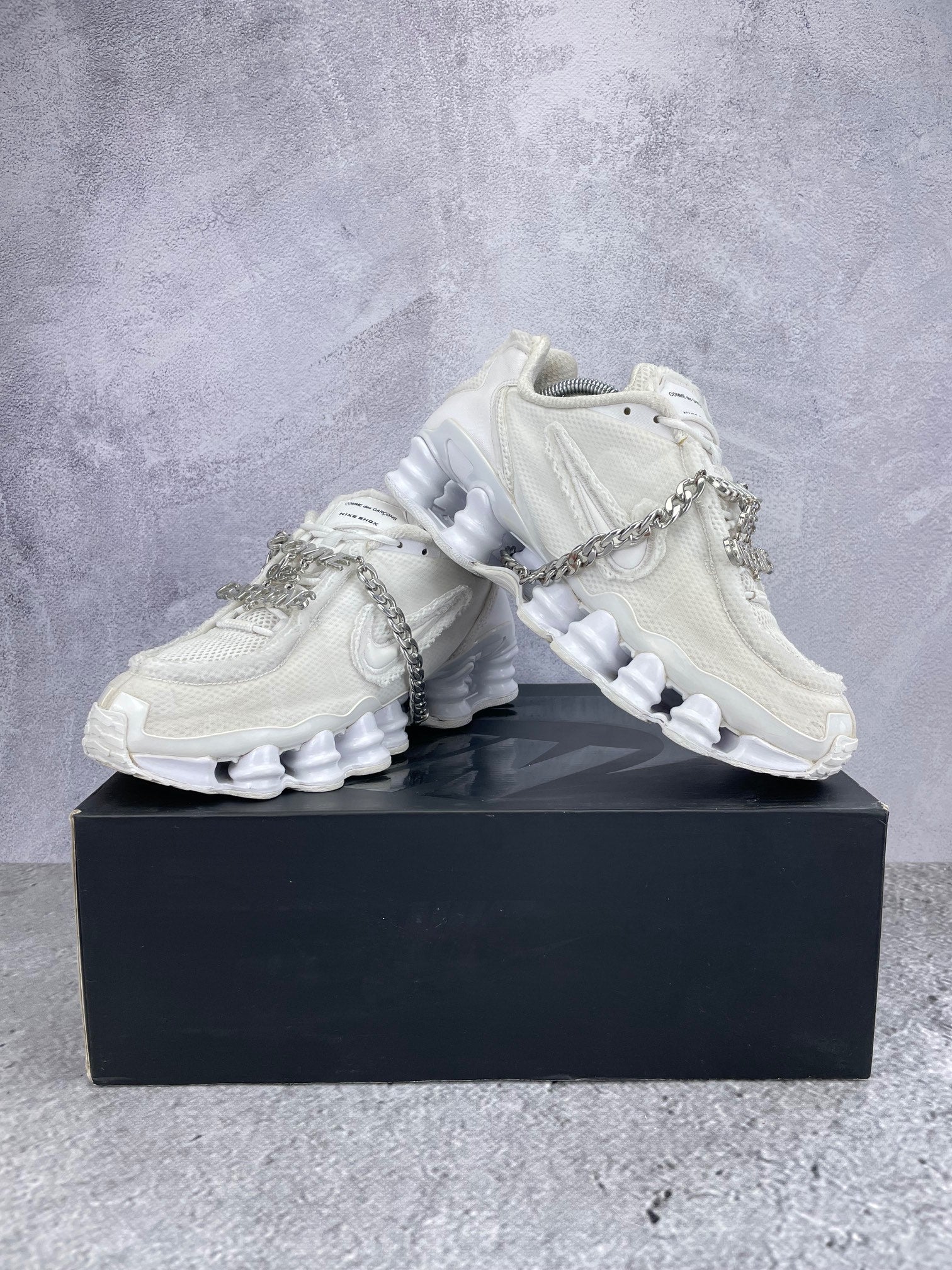 Nike Shox TL / CDG Triple White - buty sportowe, para butów, widok z boku na tle studyjnym