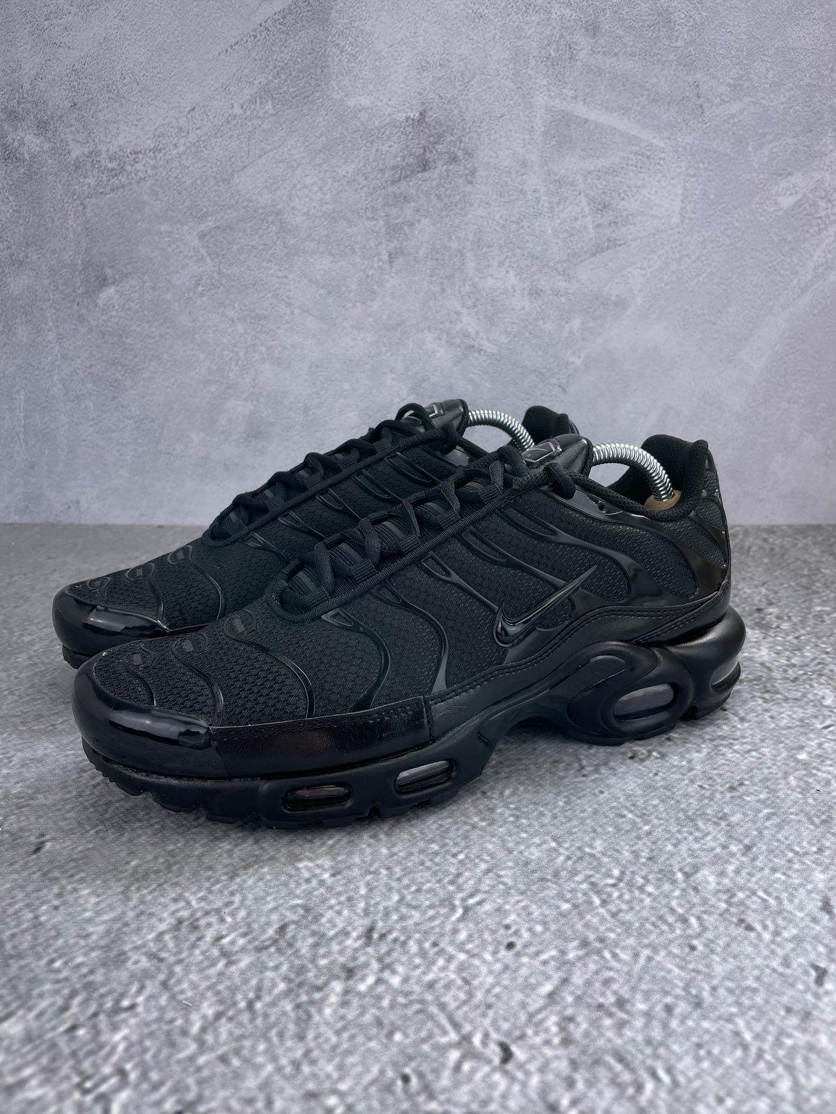 Nike Air Max Plus Triple Black - buty sportowe, widok z boku na tle studyjnym