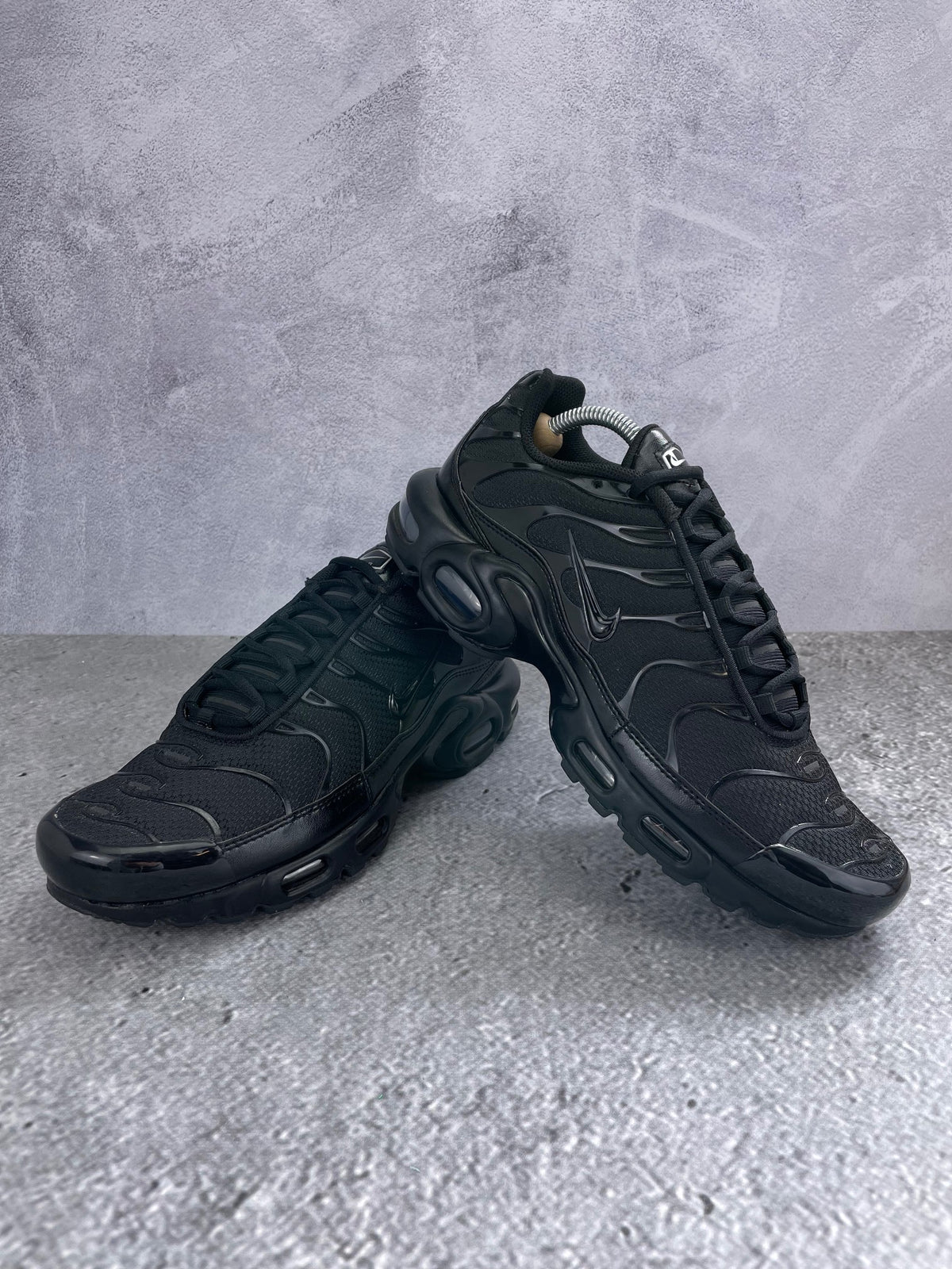 Nike Air Max Plus Triple Black - buty sportowe, para butów, widok z boku na tle studyjnym